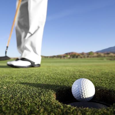 Close-up of golfer's legs and shoes with ball